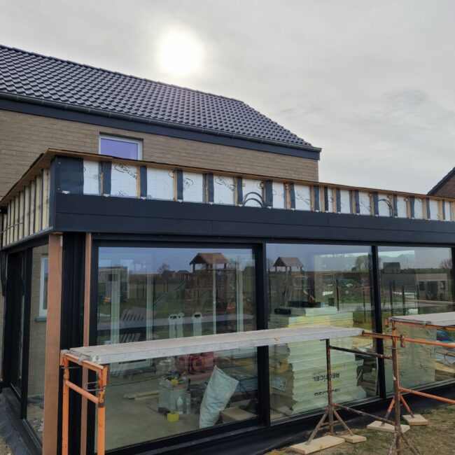 Pose du bardage de l'extension basse énergie d'une maison récente à Verlaine en province de Liège