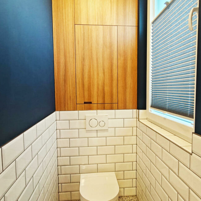 Aménagement de WC dans les sanitaires d’une entreprise à Liège avec menuiserie sur mesure et carrelage métro